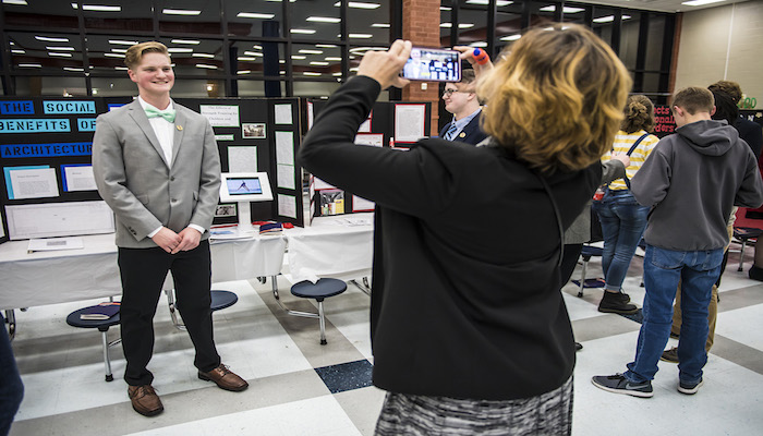 Blackman High School senior Cole Harkins poses for a photo next to his research project display during the Feb. 8 Blackman Collegiate Academy Capstone Gallery Walk in the school’s cafeteria. Harkins plans to attend MTSU and major in exercise science. (MTSU photo by Eric Sutton)