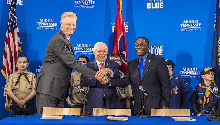 From right to left, MTSU President Sidney A. McPhee, MTSU Trustee J.B. Baker, and Larry Brown, CEO of the Middle Tennessee Council of the Boy Scouts of America, shake hands after signing a partnership Wednesday, March 7, in the Strobel Lobby at MTSU. Behind them are Cub Scouts from Scales and Rockvale elementary schools. The agreement allows the university to be a greater resource for scouting programs, particularly in science and technology. (MTSU photo by Eric B. Sutton)