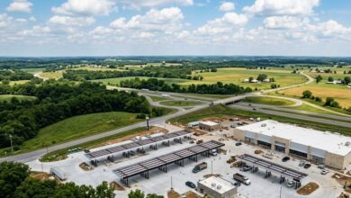 Aerial view of a large travel center and fuel canopies under construction beside a rural interstate interchange