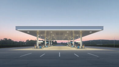 A long unbranded highway fuel canopy lit before sunrise over an empty concrete apron in Middle Tennessee, representative of a large interstate travel center (illustrative)
