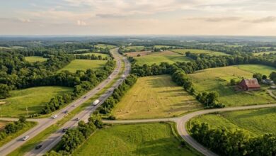 Aerial view of an interstate highway cutting through rolling Middle Tennessee farmland and hay fields (illustrative)