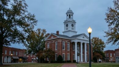 Historic red brick county courthouse with a white clock tower on a quiet Middle Tennessee town square at dusk (illustrative)