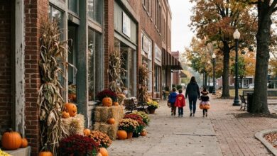 A brick-storefront square decorated with pumpkins, mums and cornstalks for fall (illustrative)