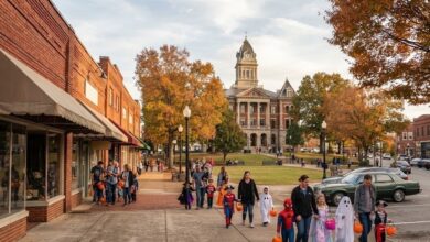 Children in Halloween costumes trick-or-treating along a small-town square (illustrative)