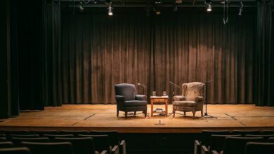 A university theatre stage set with two armchairs for a conversation (illustrative)